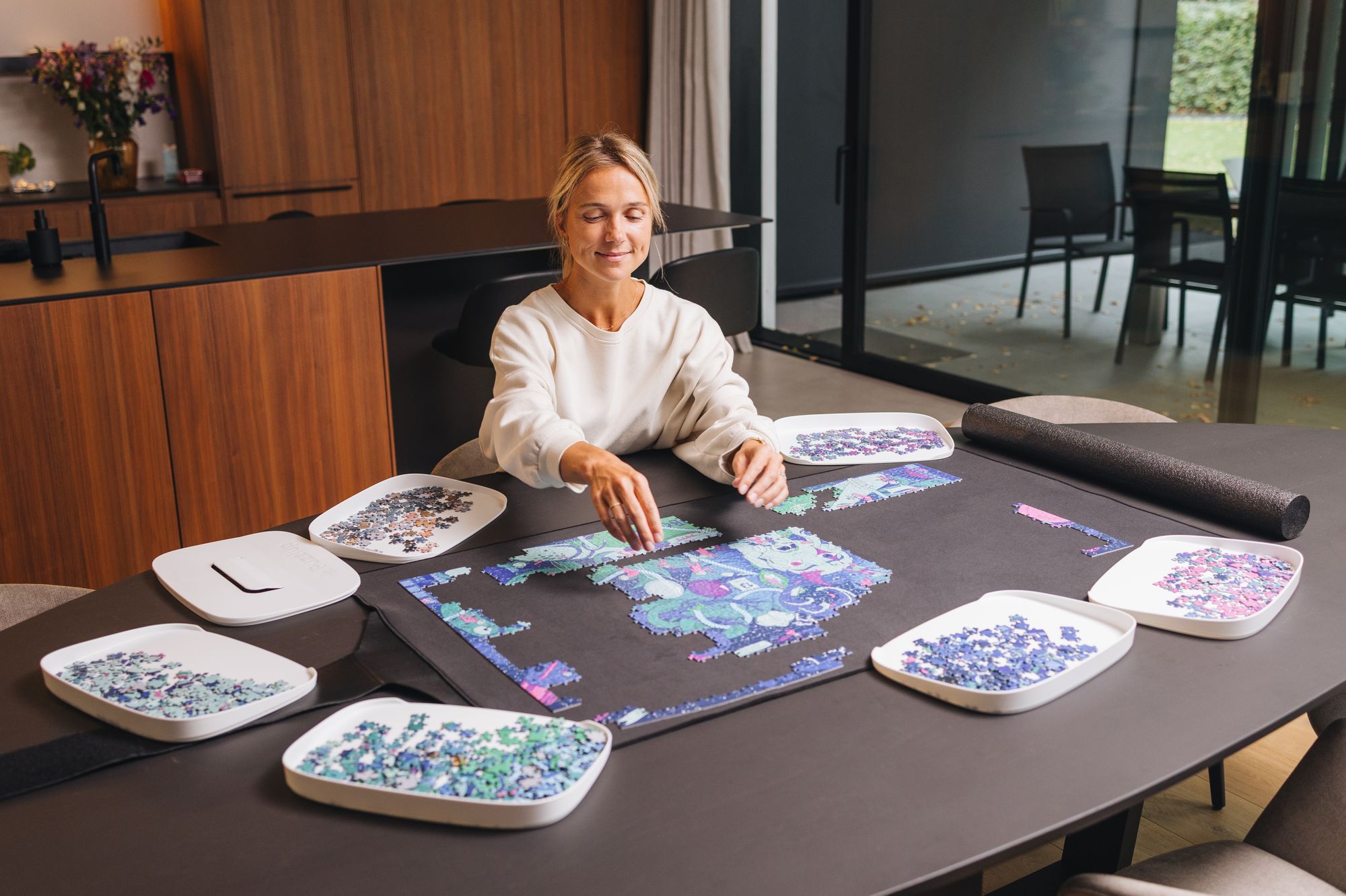 Sorting puzzle pieces into Puzzlup trays on a Puzzlup mat