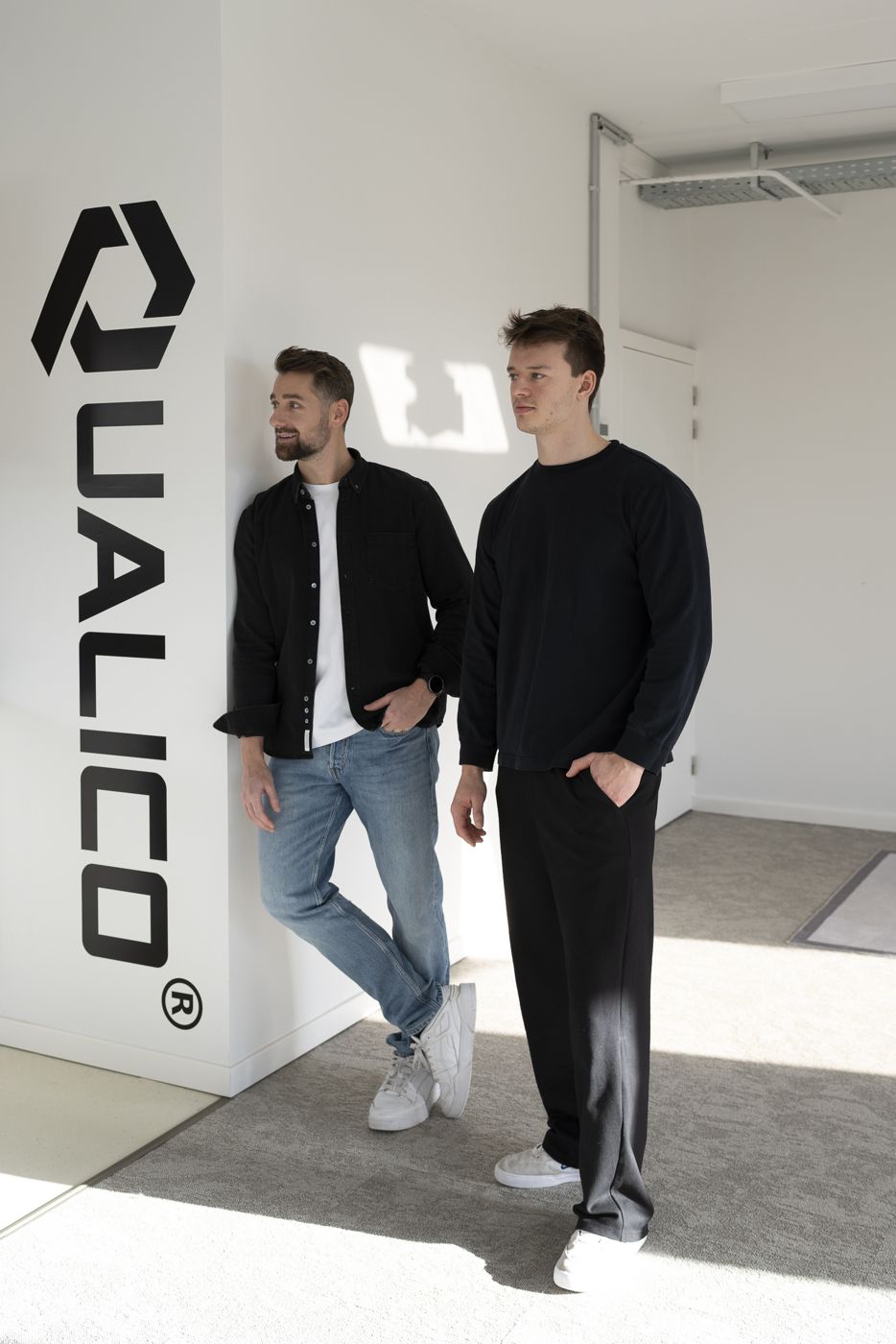 Two team members by the Qualico wall